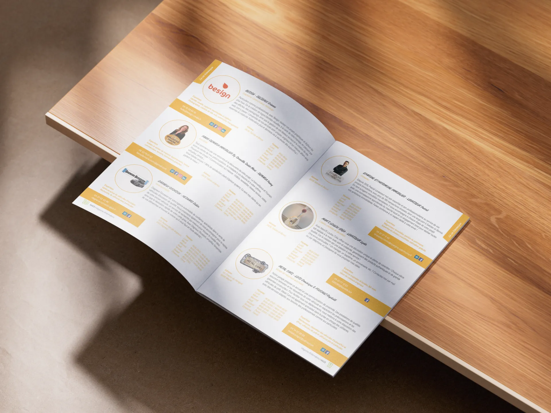 Brochure ouverte sur une table en bois, présentant des portraits, des textes et des icônes de réseaux sociaux.