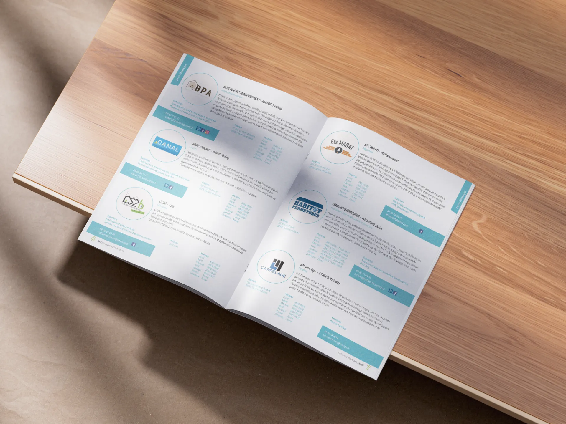 Ouverture d'une brochure sur une table en bois, présentant des logos et des textes bleus sur fond blanc.