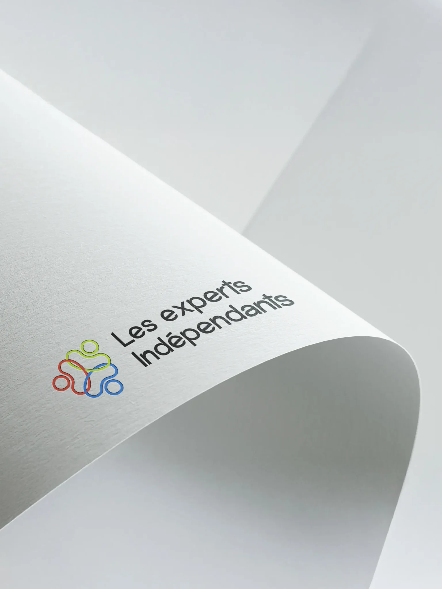 Logo des Experts Indépendants avec un symbole de trois personnes stylisées aux couleurs rouge, jaune et bleue.