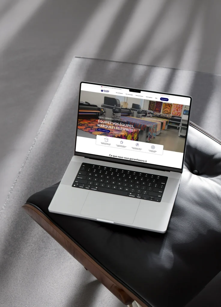 Ordinateur portable affichant le site web de SARI, une entreprise spécialisée dans la vente et l'impression textile, avec le slogan "Équipez vos équipes, marquez les esprits !"