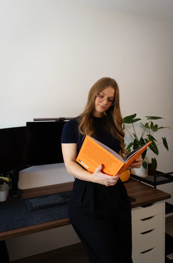 Orianne Delseaux lisant un livre de design graphique afin de trouver de l'inspiration pour la conception d'une stratégie de marque et d'une identité visuelle